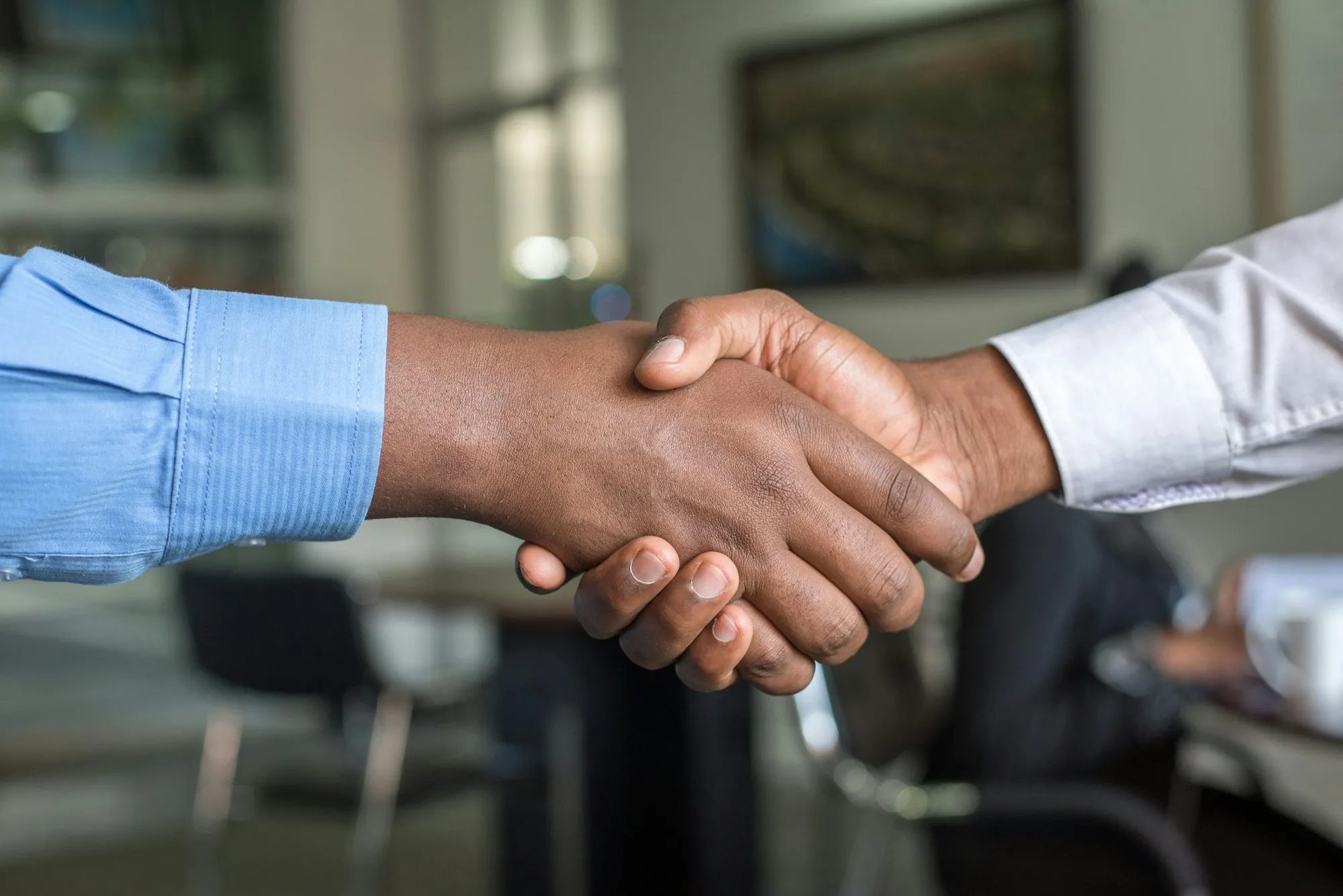 Client and project team shaking hands after a working session