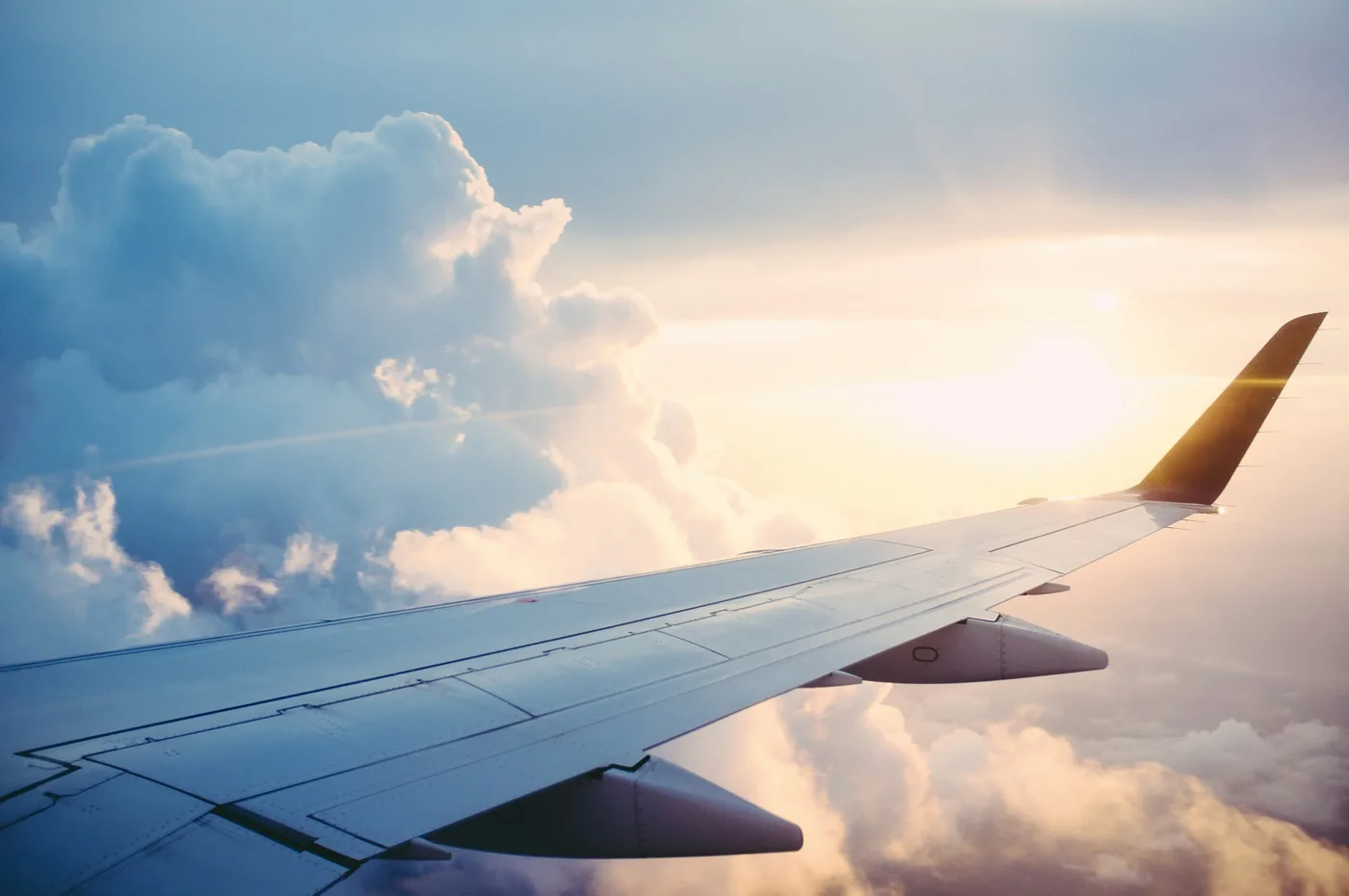 Aircraft wing above the clouds at sunset
