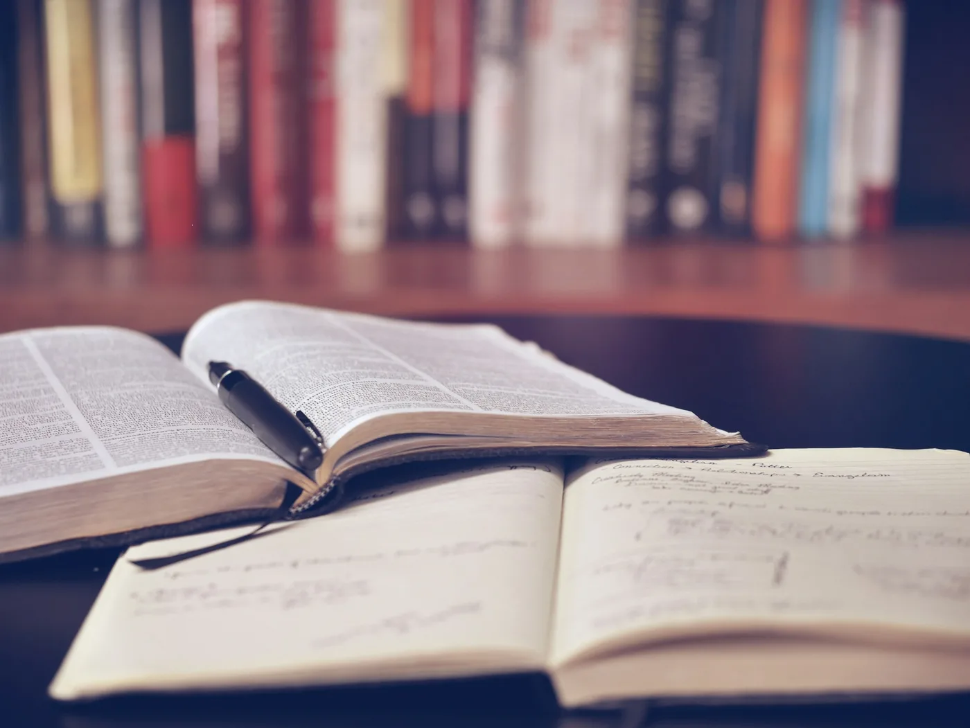 Open dictionary and notebook with handwritten notes
