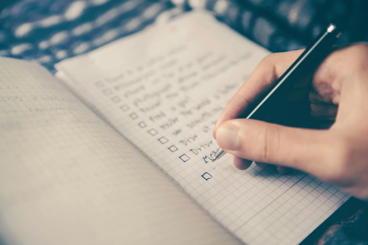 Hand ticking items on a handwritten checklist